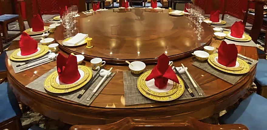 金色调瓷器，每个座位一方折好的红餐巾